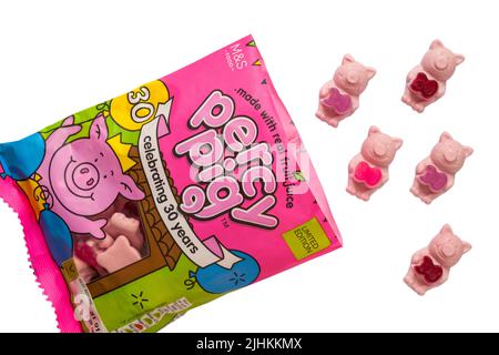 Beutel mit M&S Percy Pig Süßigkeiten feiert 30 Jahre mit echtem Fruchtsaft geöffnet mit Inhalt verschüttet isoliert auf weißem Hintergrund - limitierte Auflage Stockfoto