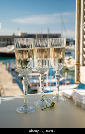 Drei Gläser französischer Champagner Sekt und Blick auf bunte Fischerboote im alten Hafen von Cassis, Provence, Frankreich, Sommerfest in PR Stockfoto