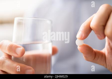 Kranker Mann, Der Medikamente Nimmt. Antibiotika In Der Hand Stockfoto