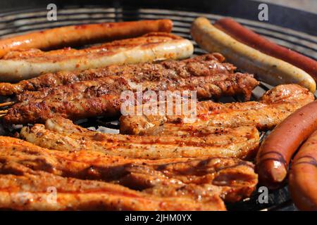 Verschiedene Fleisch- und Wurstwaren auf dem Holzkohlegrill Stockfoto