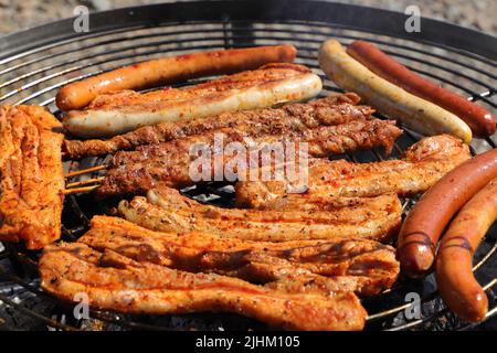 Verschiedene Fleisch- und Wurstwaren auf dem Holzkohlegrill Stockfoto