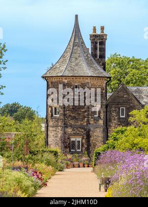 Pfad im Küchengarten, der zum achteckigen Turm mit konischem Dach des Garden Cottage in der RHS Bridgewater in Salford führt. Stockfoto