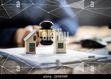 Nahaufnahme eines Richters markante Hammer zwischen Split Haus über Holz- Schreibtisch Stockfoto