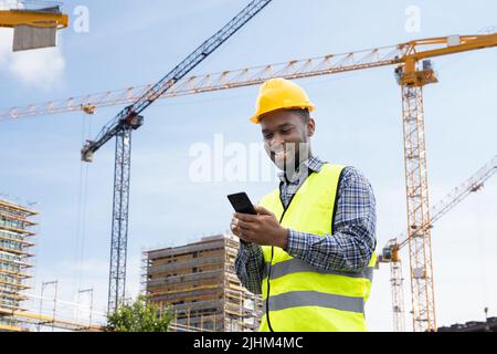 Builder Worker Mit Telefon. Kommunikation Mit Mitarbeitern Im Bauwesen Stockfoto