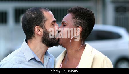 Glücklich verheiratet interracial paar küssen. Die Frau und der Mann lächelten sehr unterschiedlich Stockfoto