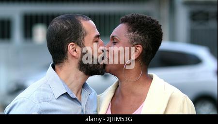 Glücklich verheiratet interracial paar küssen. Die Frau und der Mann lächelten sehr unterschiedlich Stockfoto