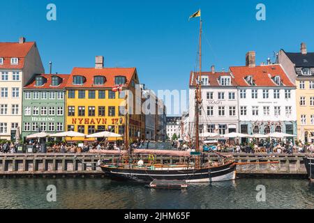 Wunderschöne Aussicht mit farbenfroher Fassade aus traditionellen Häusern und alten Holzschiffen, Kreuzfahrtbooten entlang des Nyhavn-Kanals oder des Neuen Hafens Stockfoto