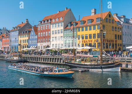 Wunderschöne Aussicht mit farbenfroher Fassade aus traditionellen Häusern und alten Holzschiffen, Kreuzfahrtbooten entlang des Nyhavn-Kanals oder des Neuen Hafens Stockfoto