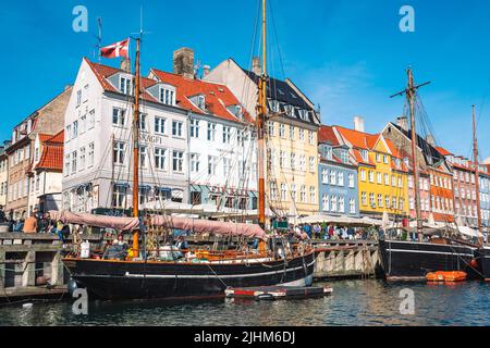 Wunderschöne Aussicht mit farbenfroher Fassade aus traditionellen Häusern und alten Holzschiffen, Kreuzfahrtbooten entlang des Nyhavn-Kanals oder des Neuen Hafens Stockfoto