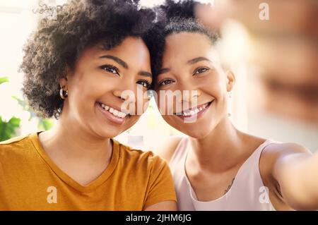 Ich halte dich für mein Leben als meine Freundin. Zwei junge Freundinnen, die zu Hause ein Selfie machen. Stockfoto