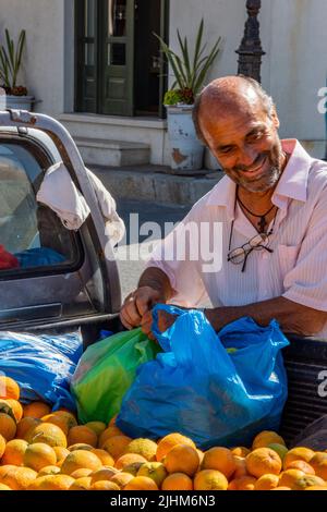 griechischer Markthändler, der frische Orangen von der Rückseite seines Pickup-Lkws auf der Insel kreta verkauft. Stockfoto