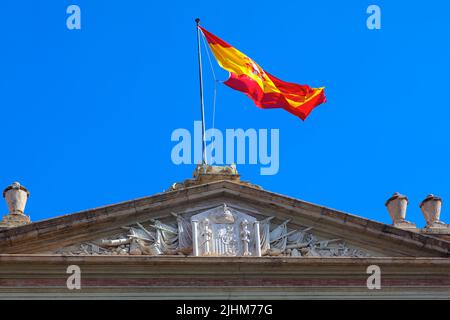 Spanische Flagge auf der Oberseite . Schwenkende Nationalflagge Spaniens, oberer Teil des Gebäudes Stockfoto