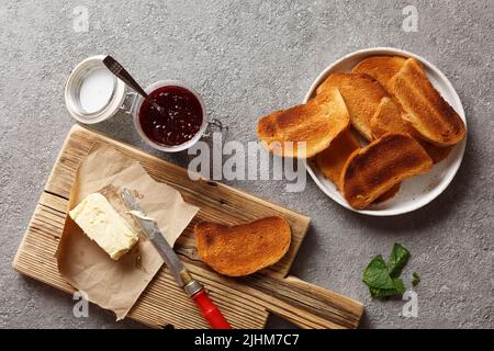 Toasts mit Butter und Marmelade in Nahaufnahme auf schwarzem Boton-Hintergrund Stockfoto