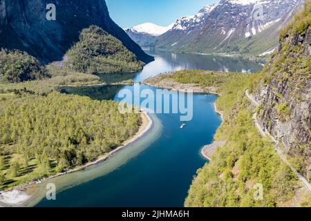 Luftaufnahme des Lovatn-Sees, lokales Schiff auf dem Weg nach Kjenndalstova, Schotterbergstraße über dem See, Norwegen. Stockfoto