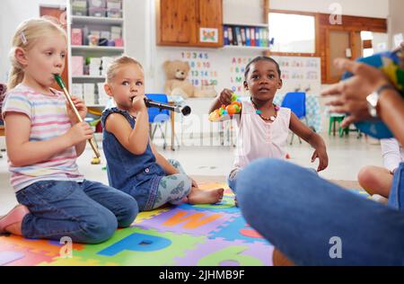 Es gibt so viele Vorteile von Musikinstrumenten für Kinder. Kinder lernen in der Klasse über Musikinstrumente. Stockfoto