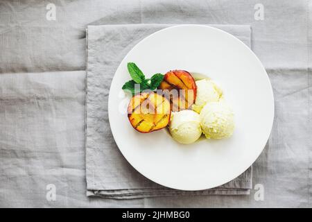 Gegrillte Pfirsiche und Zitroneneis, Dessert. Stockfoto