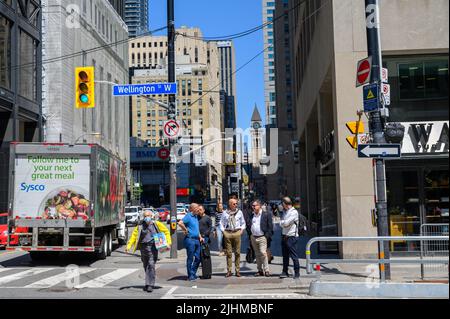 Fußgänger und Fahrzeuge an der Ecke Wellington St West und Bay St im Zentrum von Toronto, Ontario, Kanada. Stockfoto