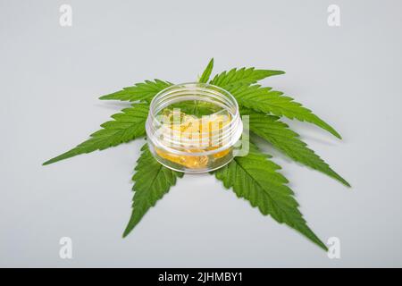 Grünes Blatt und hoher thc-Cannabis tupfen in Glasbehälter, Wachs extrahieren. Stockfoto