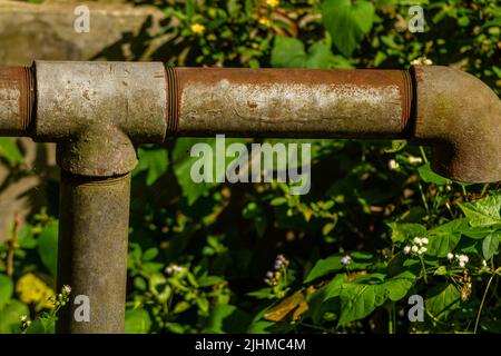 Verrostete Rohrverbindungen aus Eisen, isoliert auf einem verschwommenen Hintergrund Stockfoto