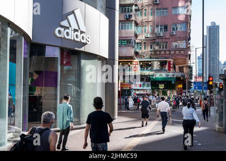 Fußgänger laufen am deutschen multinationalen Sportartikelgeschäft Adidas in Hongkong vorbei. Stockfoto