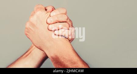 Armdrücken. Nahaufnahme. Freundlicher Händedruck, Freundschaftsgrüße, Teamarbeit, Freundschaft. Handschlag, Waffen, Freundschaft. Handrivalität vs Herausforderung Stärke Stockfoto