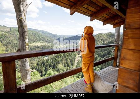 Frau genießt eine tolle Aussicht auf die Berge aus Naturhaus Stockfoto