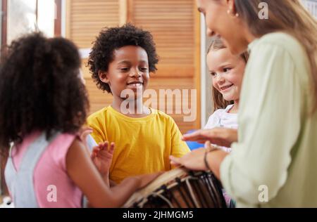 Jeder liebt Musik. Eine Frau, die ihre Klasse über Musikinstrumente unterrichtet. Stockfoto