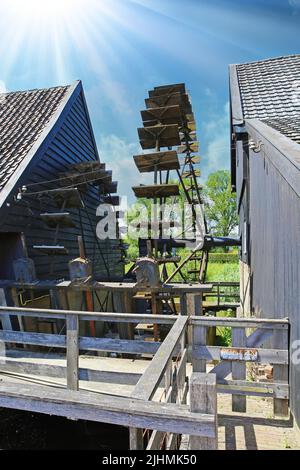 Nuenen (Opwetten), Niederlande - Juli 9. 2022: Nahaufnahme eines alten hölzernen Wasserrad in der alten holländischen Wassermühle, Sonnenstrahlen Hintergrundbeleuchtung Stockfoto