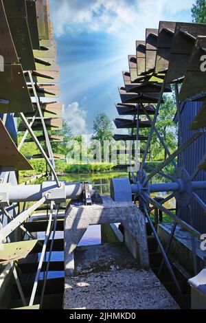 Nahaufnahme von zwei unterschossenen Metallrädern mit Wassergrist und Ölmühle, Holzpaddles from16. Century - Nuenen (Collse watermolen), Niederlande Stockfoto