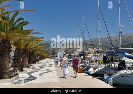 Argostili, Kefalonia, Griechenland - Juni 2022: Menschen, die an der Promenade vor dem Hafen in Argostili spazieren Stockfoto