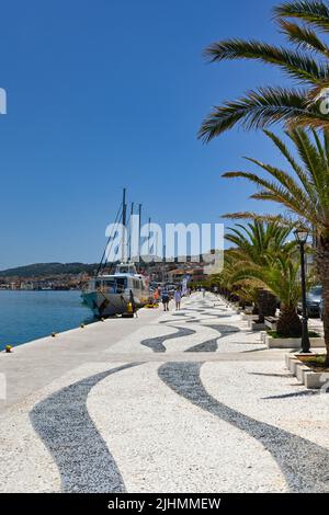 Argostili, Kefalonia, Griechenland - Juni 2022: Menschen, die an der Promenade vor dem Hafen in Argostili spazieren Stockfoto