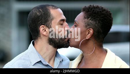 Interrassisches Paar küsst sich gegenseitig, afrikanische Frau und hispanischer Ehemann küssen sich draußen Stockfoto