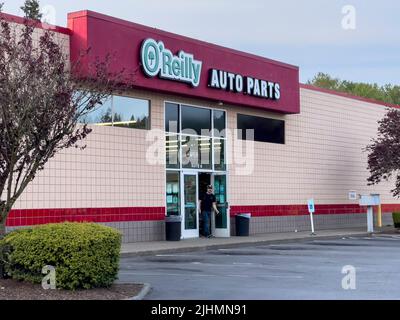 Lynnwood, WA USA - ca. Mai 2022: Weitansicht eines Mannes, der einen O'Reilly Autoteile-Laden verlässt. Stockfoto