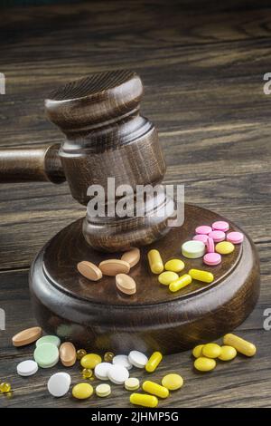 Holzgavel mit Drogen auf dem Tisch, Nahaufnahme. Forensische Medizin, pharmazeutische Probleme in der medizinischen Praxis, abgelaufene Medikamente, gefälschter Markt. Stockfoto