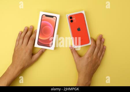 Tjumen, Russland-18. Juli 2022: IPhone 12 mini Produkt rot mit Einzelhandelsverpackung. Draufsicht, gelber Hintergrund Stockfoto