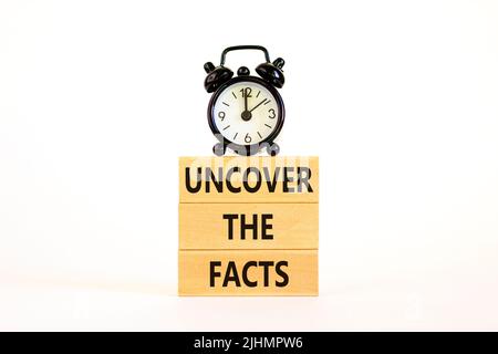 Entdecken Sie das Facts-Symbol. Concept Words enthüllen die Fakten auf Holzblöcken auf einem schönen weißen Hintergrund. Schwarzer Wecker. Unternehmen und Stockfoto