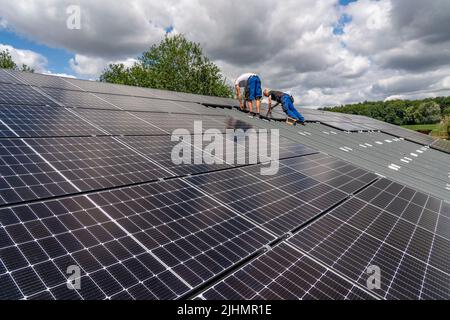 Installation von Solarmodulen auf dem Dach einer Scheune, einer Farm, über 240 Photovoltaikmodule sind auf dem Dach installiert, NRW, Deutschland Stockfoto