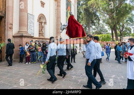 Mexikanische Christen, tragen eine Statue von Jesus Christus, während einer Palmsonntagsprozession im Basílica de Nuestra Señora de la Salud, oder Basilika unserer Lieben Frau von Gesundheit, zur Feier des traditionellen Sonntagsgottesdienstes zum Beginn der heiligen Woche, 10. April 2022 in Patzcuaro, Michoacan, Mexiko. Stockfoto