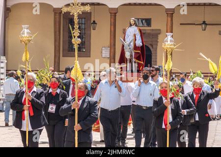 Mexikanische Christen, tragen eine Statue von Jesus Christus, während einer Palmsonntagsprozession im Basílica de Nuestra Señora de la Salud, oder Basilika unserer Lieben Frau von Gesundheit, zur Feier des traditionellen Sonntagsgottesdienstes zum Beginn der heiligen Woche, 10. April 2022 in Patzcuaro, Michoacan, Mexiko. Stockfoto