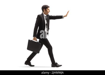 In voller Länge Profilaufnahme eines wütenden Geschäftsmannes, der auf weißem Hintergrund läuft und gestikuliert hält Stockfoto