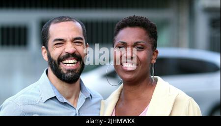 Verheiratet interracial Paar lachen und lächeln. Afrikanische Frau und hispanischer Mann mit gemischter Rasse. Die Menschen im echten Leben lachen und lächeln Stockfoto