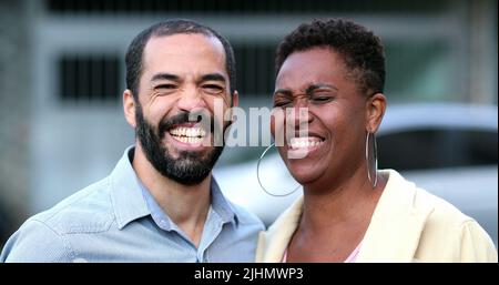 Verheiratet interracial Paar lachen und lächeln. Afrikanische Frau und hispanischer Mann mit gemischter Rasse. Die Menschen im echten Leben lachen und lächeln Stockfoto