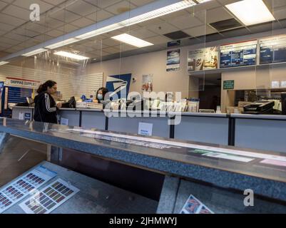 Mill Creek, WA USA - ca. Mai 2022: Schräge Ansicht von Leuten, die Pakete in einem Postamt verschicken. Stockfoto
