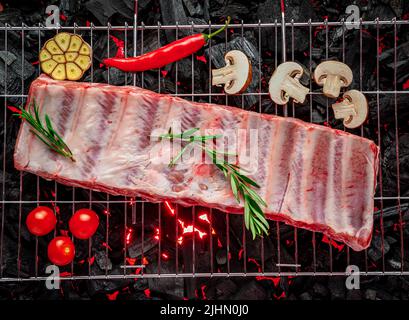 Rohe Rippen auf dem Grill, brennende Kohlen auf dem Grill. Heimpicknick Stockfoto