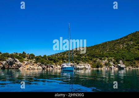 Wunderschöne Aussicht auf ein Segelboot, das auf der Insel Peristera in der Nähe des berühmten Schiffswracks von Peristera, Alonissos, Griechenland, verankert ist Stockfoto