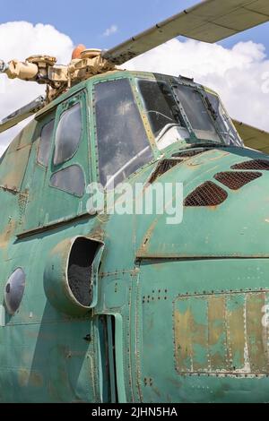 Seitenansicht des alten, verlassenen Militärhubschraubers. Gebrochener, nicht funktionstüchtiger sowjetischer Hubschrauber.vertikal. Stockfoto