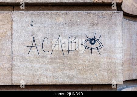 Neben einem offenen Auge sind die Buchstaben ACAB, die für "All Cops Are Bastards" stehen, an einer Wand in der Hobson Street, Cambridge, Großbritannien, graffiti geklebt Stockfoto