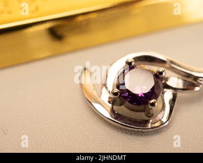 Nahaufnahme eines Pendelstegs aus Weißgold mit glänzendem purpurem Stein Stockfoto