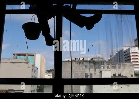 Abseilen Mann arbeiten an externen Fensterputzdienst und Gebäudereparatur. Arbeiter Abseilen Renovierung Gebäude. Zimmermann, Bauarbeiter Stockfoto