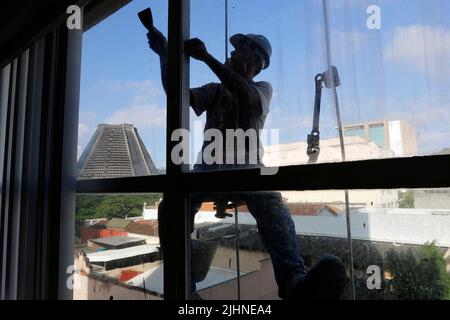 Abseilen Mann arbeiten an externen Fensterputzdienst und Gebäudereparatur. Arbeiter Abseilen Renovierung Gebäude. Zimmermann, Bauarbeiter Stockfoto